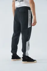 Pantalón de jogging gris oscuro de felpa con puños, cintura ajustable con cordón y logo estampado en la pierna.