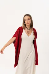 Ruana tejida de hilo color rojo con lurex y terminación de flecos.