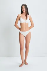 Conjunto de ropa interior de encaje blanco, compuesto por un corpiño triangular con breteles finos y una bombacha tipo vedetina.