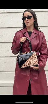 Cartera rígida negra de cuero con tachas plateadas y tres combinaciones de cuero diferentes que aportan textura. Tiene herrajes y cierre metálico plateado marca YKK. Cuenta con un asa fina para llevar al hombro o en la mano y una correa larga extra regulable.