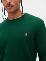 Buzo de tejido de punto color negro, con cuello redondo y un pequeño logo bordado en el pecho.