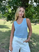 Blusa de tejido de punto celeste, sin mangas, con escote en V y detalles calados.