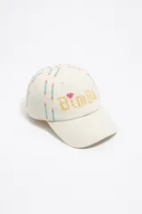 Gorra de béisbol color crudo, con bordados multicolores en forma de cruces y la palabra 'Bimba' en el frente.