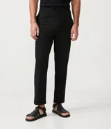 Pantalón de vestir negro, de corte slim cropped, con cintura elástica, cierre con cremallera y bolsillos laterales.