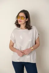 Blusa italiana color celeste con bordado de plumas al tono en el frente, confeccionada en lino y algodón.