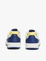 Zapatillas Tommy Jeans de corte bajo, confeccionadas en piel color blanco y azul con detalles en amarillo. Presentan suela cupsole, detalle de ventilación en la parte superior, logo de Tommy Jeans en relieve en la entresuela y parche de Tommy en el lateral.