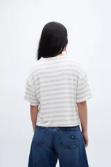 Remera holgada a rayas horizontales color crudo y beige, con mangas cortas y tajos laterales.
