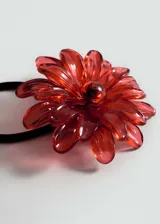 Coletero con elástico negro y aplique de flor color crema.
