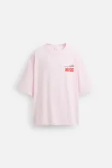 Camiseta rosa de corte holgado, cuello redondo y manga corta. Estampado frontal con texto en rojo "Amalfi Coast" y estrellas.