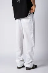 Pantalón de lino color beige, de corte recto y holgado, con cintura elastizada y cordón ajustable. Presenta bolsillos laterales amplios.