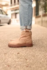 Bota corta color taupé con caña baja, corte lateral elástico y suela track.