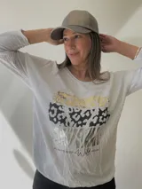 Remera negra de algodón con estampado de animal print en dorado, plateado y gris.