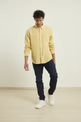 Camisa azul marino de lino y algodón, con cuello abotonado, manga larga con puños enrollados, bolsillo de parche en el pecho y cierre frontal con botones.