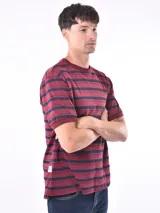 Remera de manga corta color bordó con rayas horizontales azul marino, cuello redondo y puños en color liso.