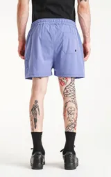 Short de baño color lavanda, de calce regular, con cintura elástica y cordón ajustable. Posee cuatro bolsillos, incluyendo bolsillos cargo con tapa en los laterales.