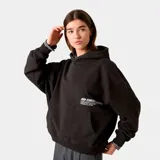 Buzo hoodie negro de corte oversize con estampa en la espalda con el logo de Eme Studios y texto "Always grateful for my roots, crafted with care 5135, veteran collection".
