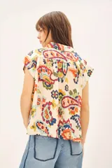 Camisa de corte amplio con cuello camisero y botones a tono.