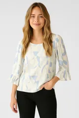 Blusa de viscosa estampada en tonos celeste y blanco, con cuello redondo y mangas 3/4 con volados.