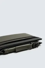 Billetera color verde oliva de acabado engomado con monedero. Tiene compartimento principal para billetes, seis posiciones internas para tarjetas y dos externas. En uno de los laterales tiene un monedero con cierre de cremallera.