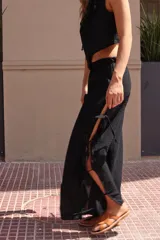 Pantalón negro de tejido ligero, corte holgado, cintura elastizada y aberturas laterales con lazos.