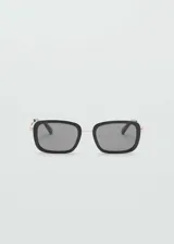 Lentes de sol cuadrados con montura de pasta negra, puente metálico y lentes grises.