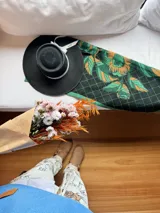 Pashmina estampada con diseño de rombos y hojas en tonos verde, negro y beige.