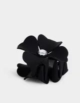 Broche negro con forma de flor y aplique de strass en el centro.