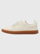 Zapatillas deportivas de cuero color blanco hueso con detalles en gamuza y suela de goma color caramelo.