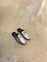 Sleepers color plateado con detalle de herraje metálico en el empeine y suela negra.