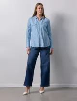 Camisa celeste de lyocell, marca Zac & Rachel. Cuello con solapa y abertura central con botones. Delantera con bolsillos.