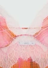 Top con estampado de cuadros en tonos rosados y naranjas, con terminaciones de encaje blanco, tirantes finos, escote de pico y tejido semitransparente.