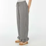 Pantalón largo de tela con estampado vichy en blanco y negro, corte palazzo, cintura alta con elástico y volantes en el ruedo.