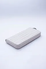 Billetera color beige con textura símil cocodrilo, cierre perimetral, múltiples ranuras para tarjetas, documentos y billetes, y bolsillo interior con cierre para monedas.