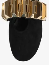 Zapato plano negro de tela con punta fina y aplique metálico dorado en el empeine.