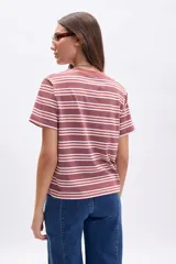 Remera de manga corta con cuello redondo, corte recto y estampado de rayas horizontales en tonos marrón/terracota, blanco y beige.