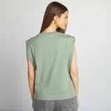 Camiseta verde sin mangas con cuello redondo y hombreras.