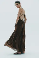 Vestido midi marrón con escote en V, tirantes finos ajustables y espalda descubierta con lazadas.