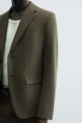 Blazer slim fit color verde oliva confeccionada en tejido con viscosa. Cuello con solapas de muesca, manga larga acabada en puño con detalle de botones, bolsillo de vivo en pecho y de solapa en cadera. Detalle bolsillo interior, bajo con aberturas en espalda y cierre frontal con botones.
