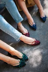 Bailarinas con aberturas laterales, de raso flocado verde botella. Cuentan con cordones del mismo tono para atar y plantilla de lana.