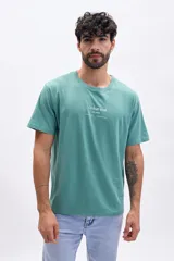 Remera verde de manga corta con estampa frontal con la frase "Urban Trek city pulse street vibe subway beat".