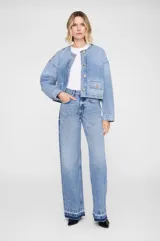 Jean de corte baggy y pierna ancha, confeccionado en denim de algodón sin elasticidad con lavado vintage medio. Presenta tiro alto, cierre con cremallera, diseño clásico de cinco bolsillos y ruedo al corte con efecto desgastado.