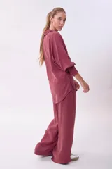 Camisa de manga larga color rosado oscuro/terracota, con cuello camisero y botones frontales. Presenta un calce holgado y tejido con caída.