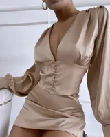 Camisa color beige de satén con escote en V y abotonada al frente, de mangas largas con puños abotonados.