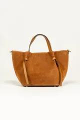 Cartera tote de gamuza color marrón con doble asa de mano y tiras de cuero decorativas en los laterales.
