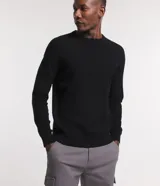 Suéter negro de algodón con cuello redondo y textura de punto.