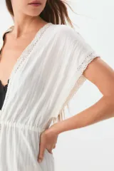 Túnica blanca de ratier de algodón con detalles de puntilla en el escote y lazo para ajustar en la cintura.