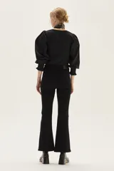 Jean negro de tiro medio con silueta levemente acampanada desde la rodilla.