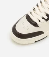 Championes urbanos de cuero sintético color crema con detalles en marrón.