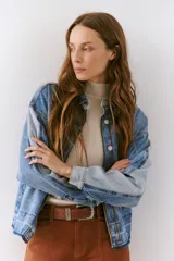 Chaqueta de jean azul con corte clásico, botones frontales y bolsillos laterales.