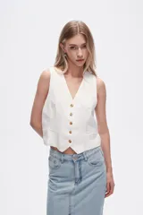 Chaleco blanco sin mangas con cuello en V y cierre frontal con botones.